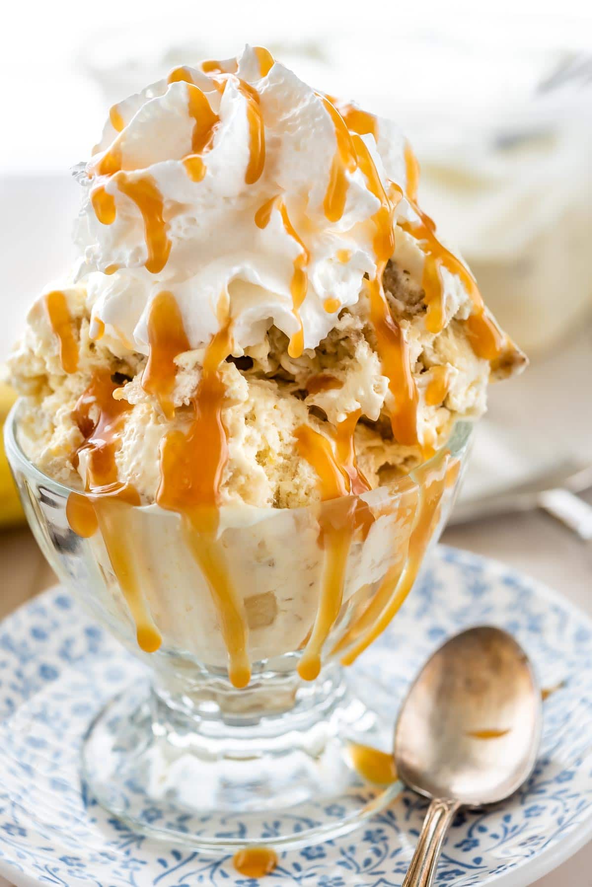 Banana cream pie ice cream topped with whipped cream and caramel sauce in a serving dish