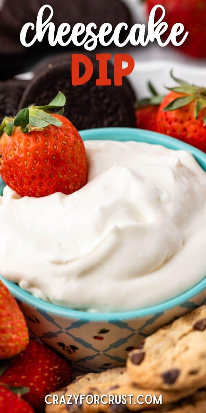 Close up shot of cheesecake dip with a strawberry in it and recipe title on top of image