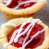 Close up shot of two cherry pie cups with recipe title on top of image