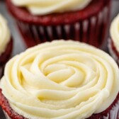 Red velvet cupcakes with cream cheese frosting and recipe title on top of image
