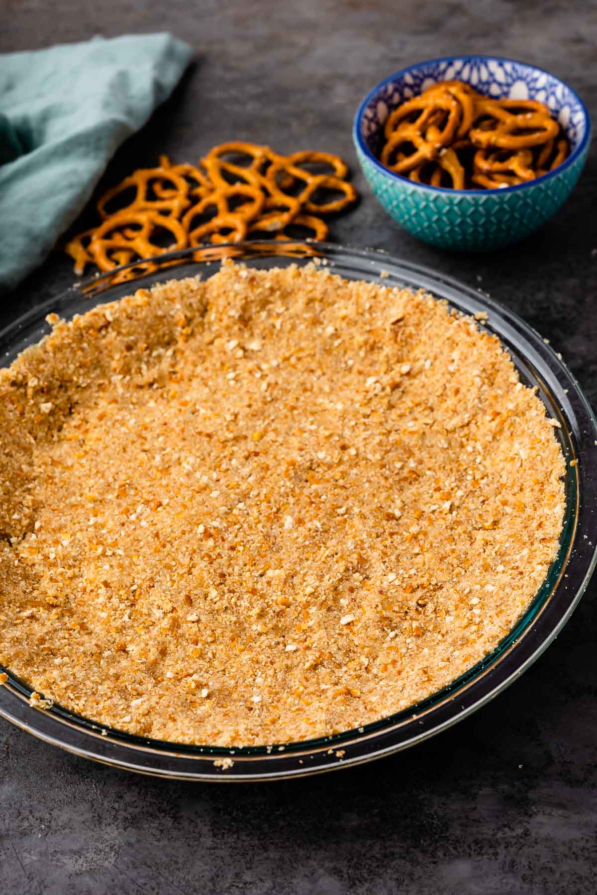 Pretzel crust in a glass pie dish next to pretzels