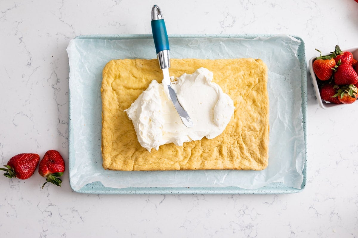 bars on cookie sheet with frosting on top.