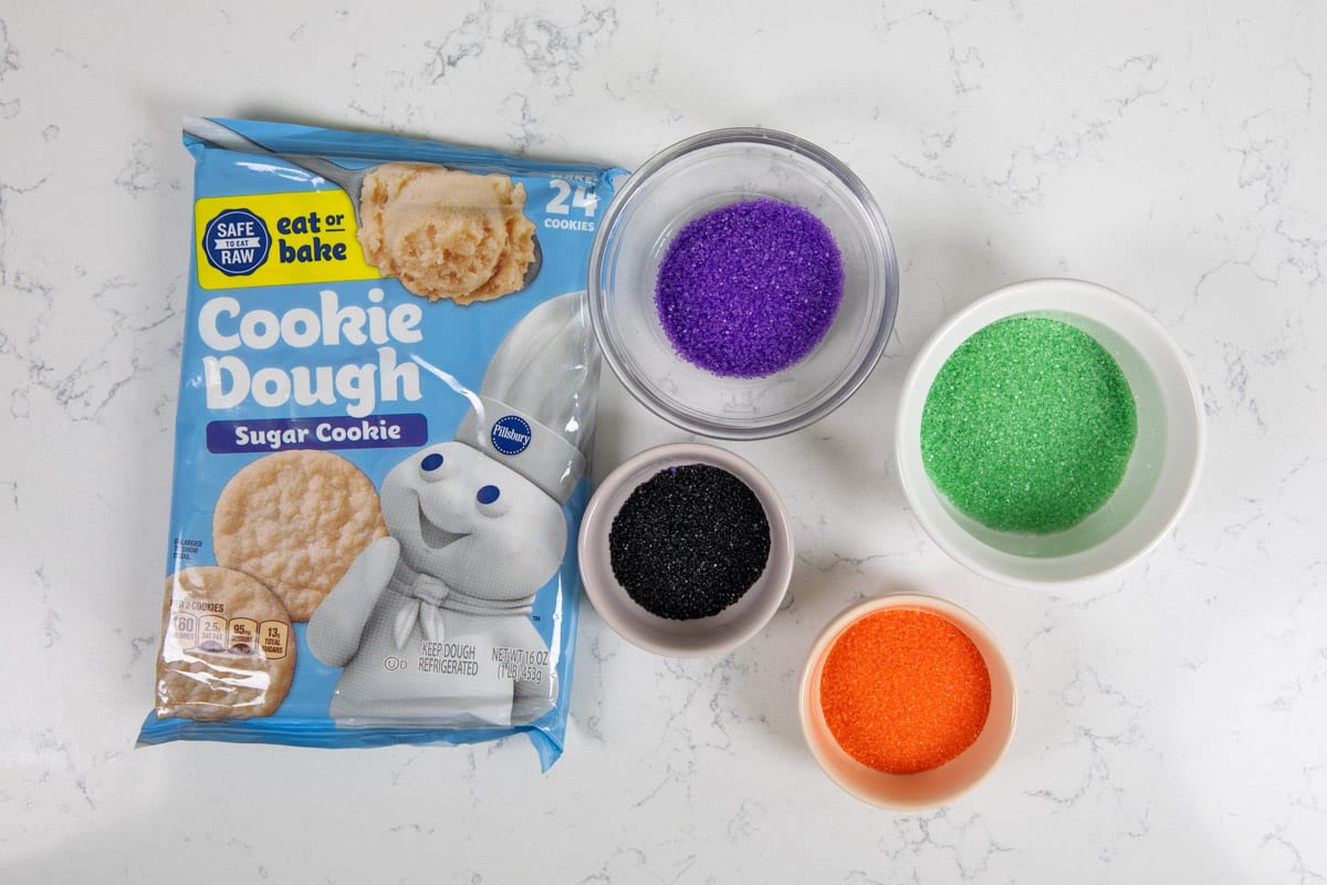 cookie dough package with bowls of colored sugar.
