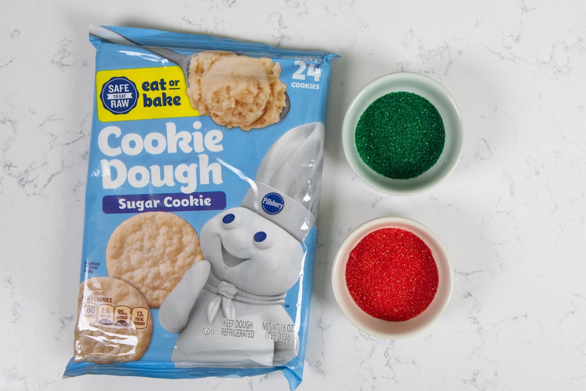 cookie dough package with bowls of colored sugar.