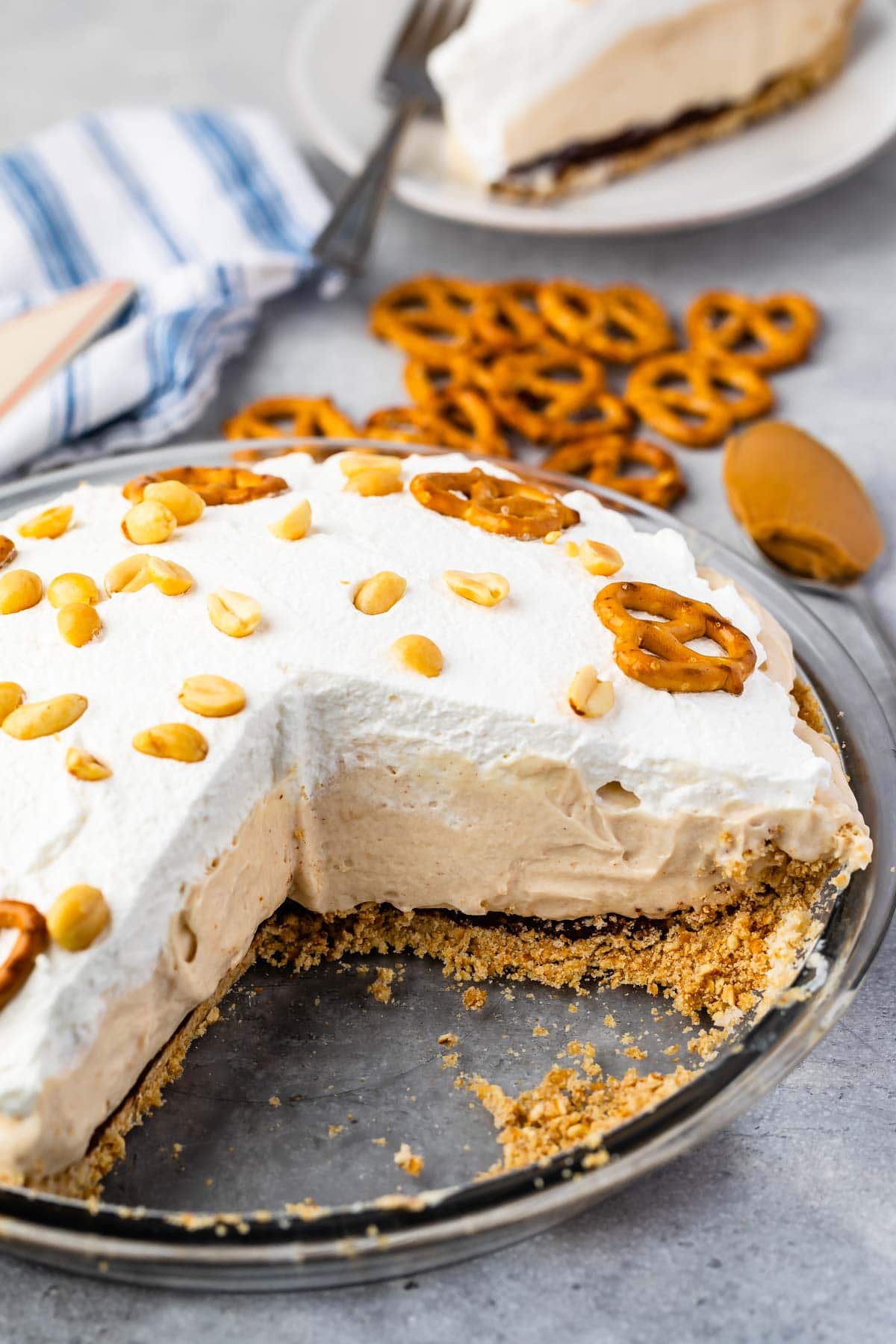 Pretzel peanut butter pie in glass pie dish with one slice missing