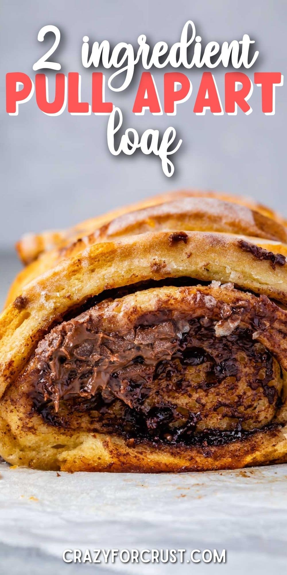 Chocolate cinnamon roll pull apart bread on parchment paper with recipe title on top of image
