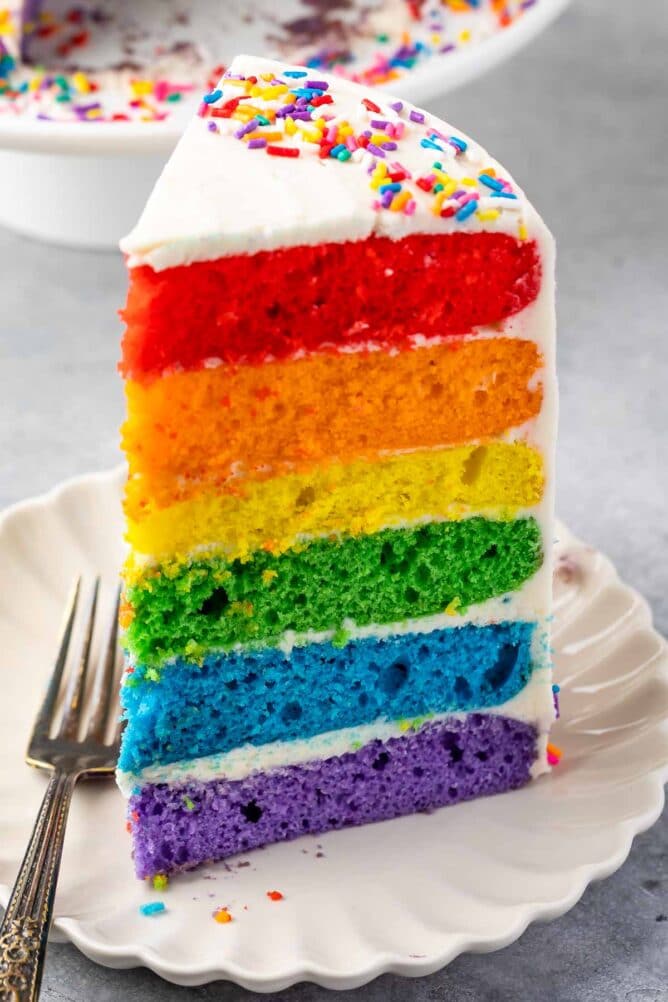 slice of rainbow cake on white plate