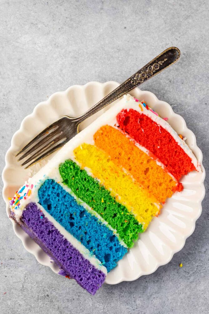 slice of rainbow cake on white plate