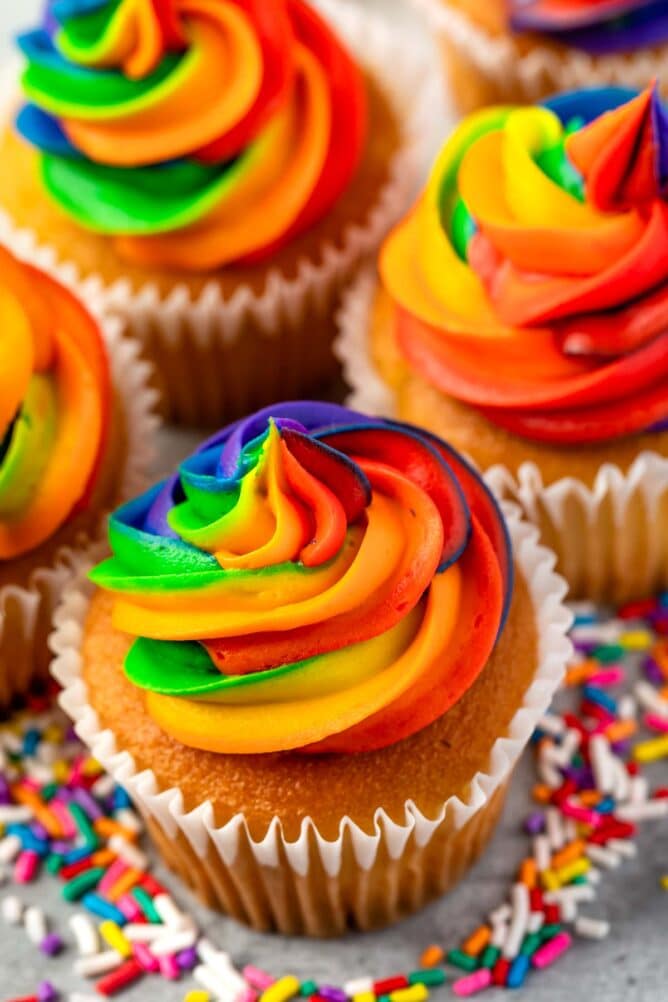 Overhead shot of rainbow swirl frosting on top of vanilla cupcakes