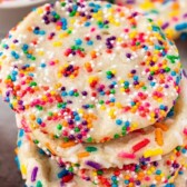 Four 2 ingredient sprinkle sugar cookies stacked on top of eachother with recipe title on top of image