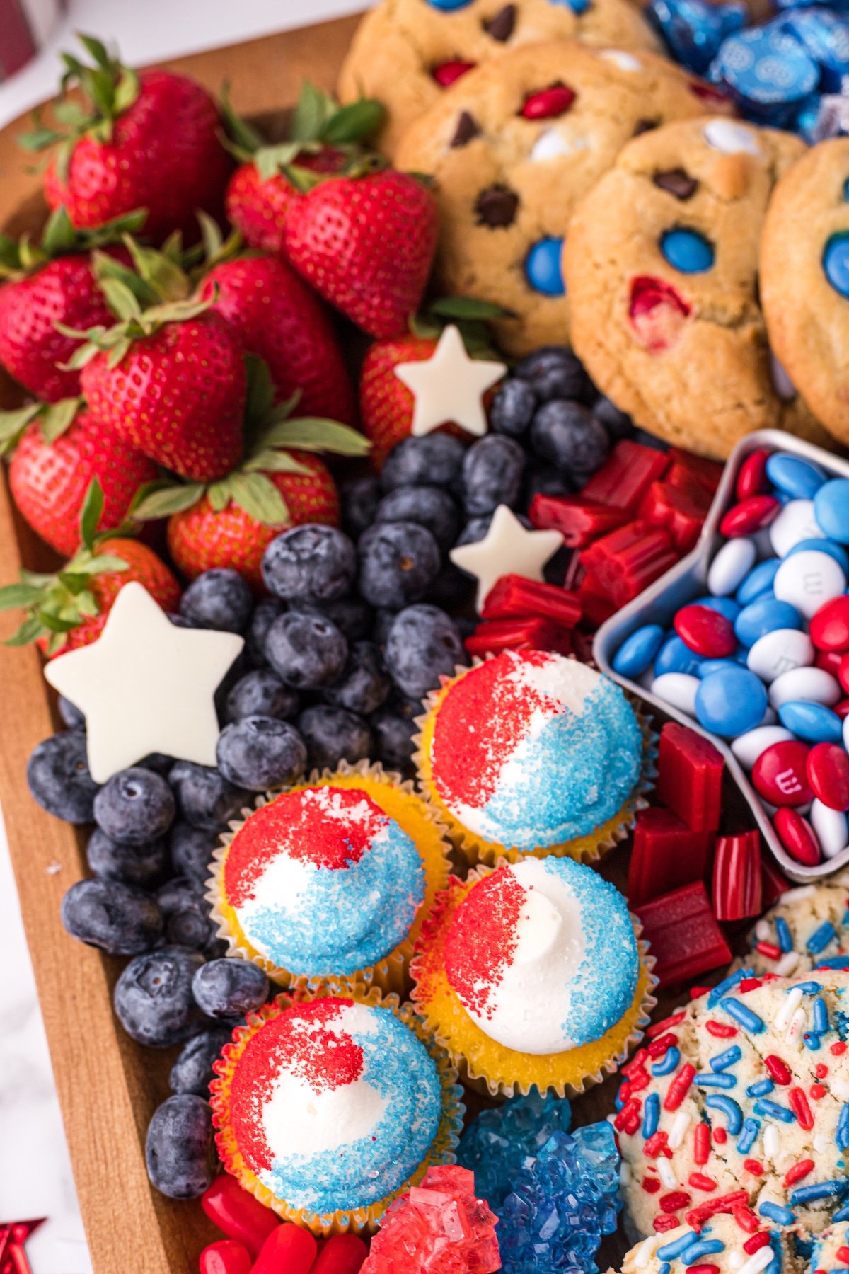 Close up shot of 4th of july dessert board filled with red, white and blue themed snacks and fruit