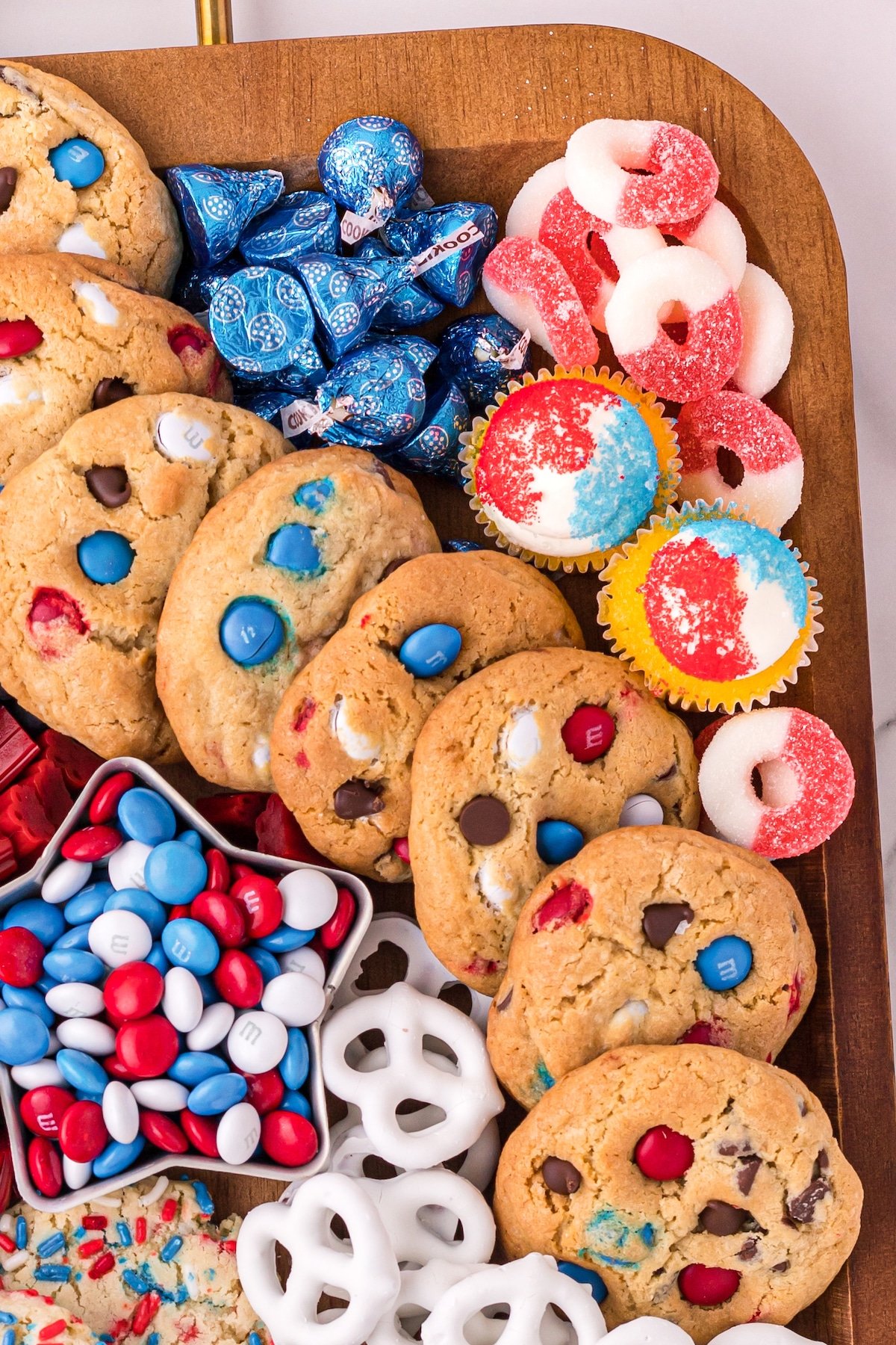 Overhead shot showing top right corner of 4th of july dessert board with candy, pretzels and cookies