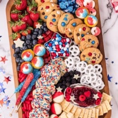 Overhead shot of 4th of july dessert board filled with red, white and blue snacks on a festive table