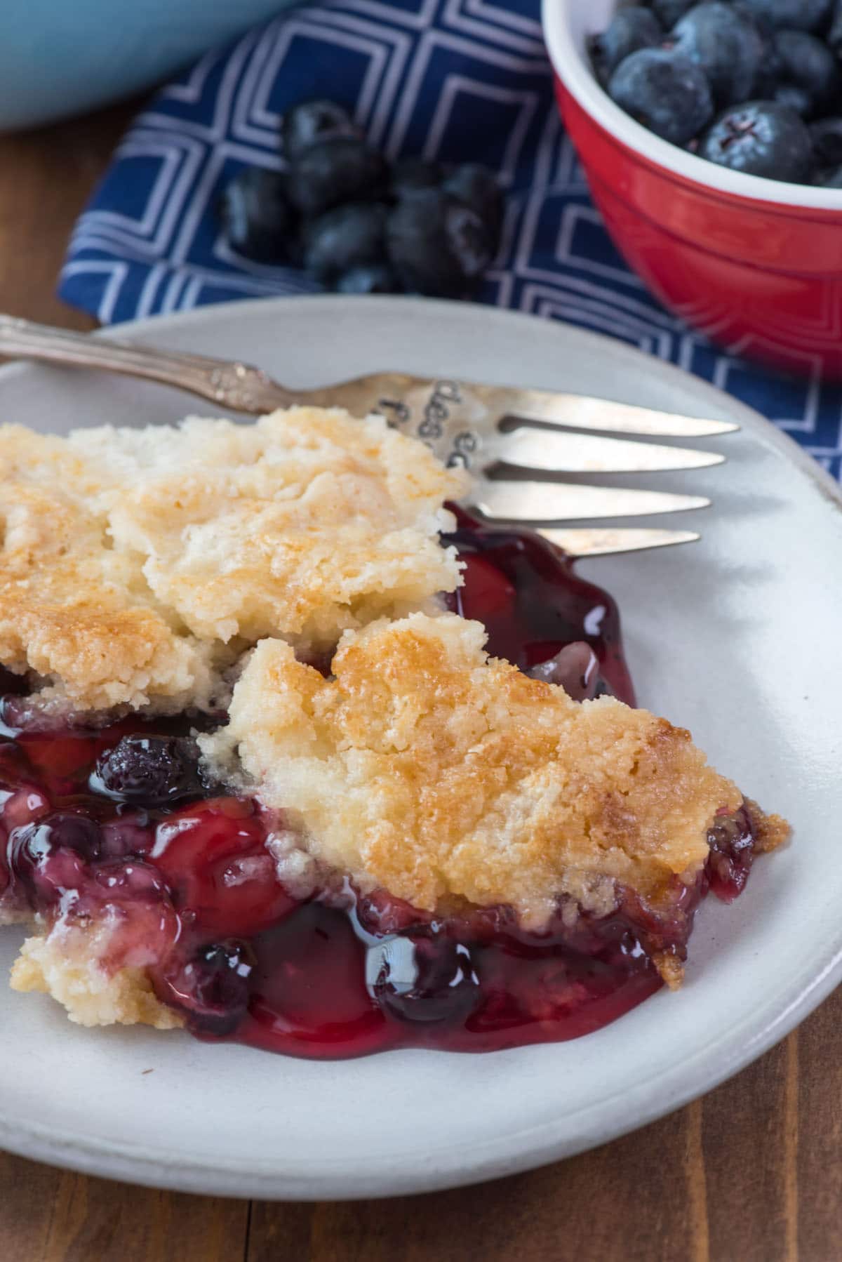 berry dump on a white plate and a fork in the back on the plate