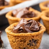 one Nutella cup with a spoonful of Nutella sitting next to it