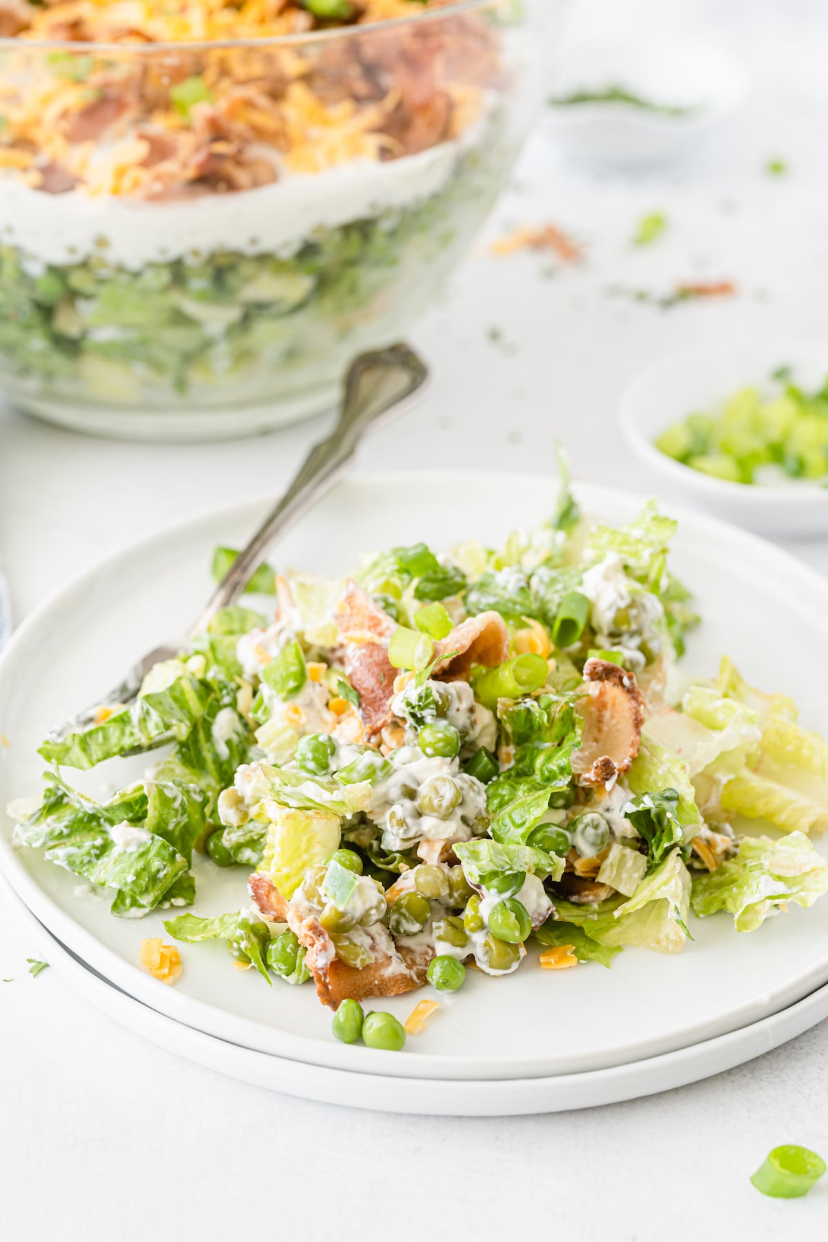 some salad sitting on a white plate with a silver fork