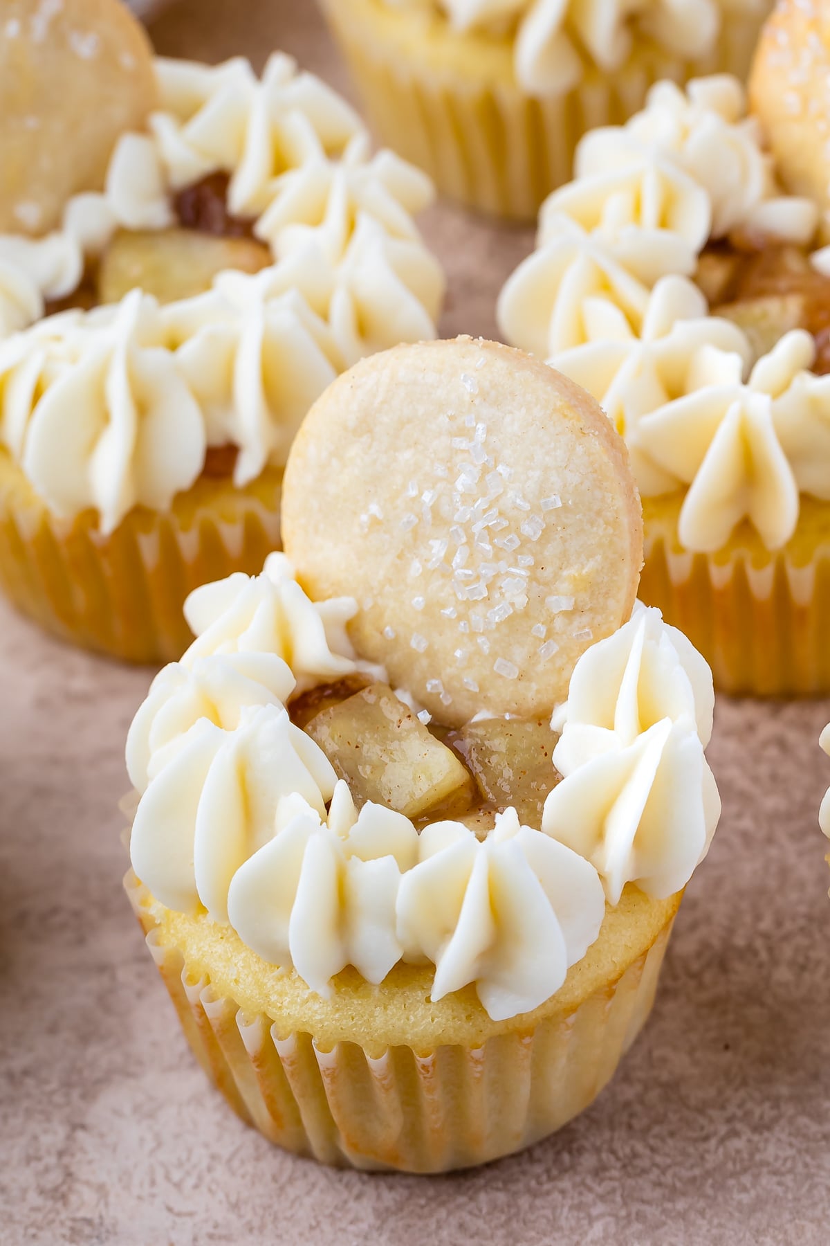 mini cupcakes with frosting and small apple slices on top