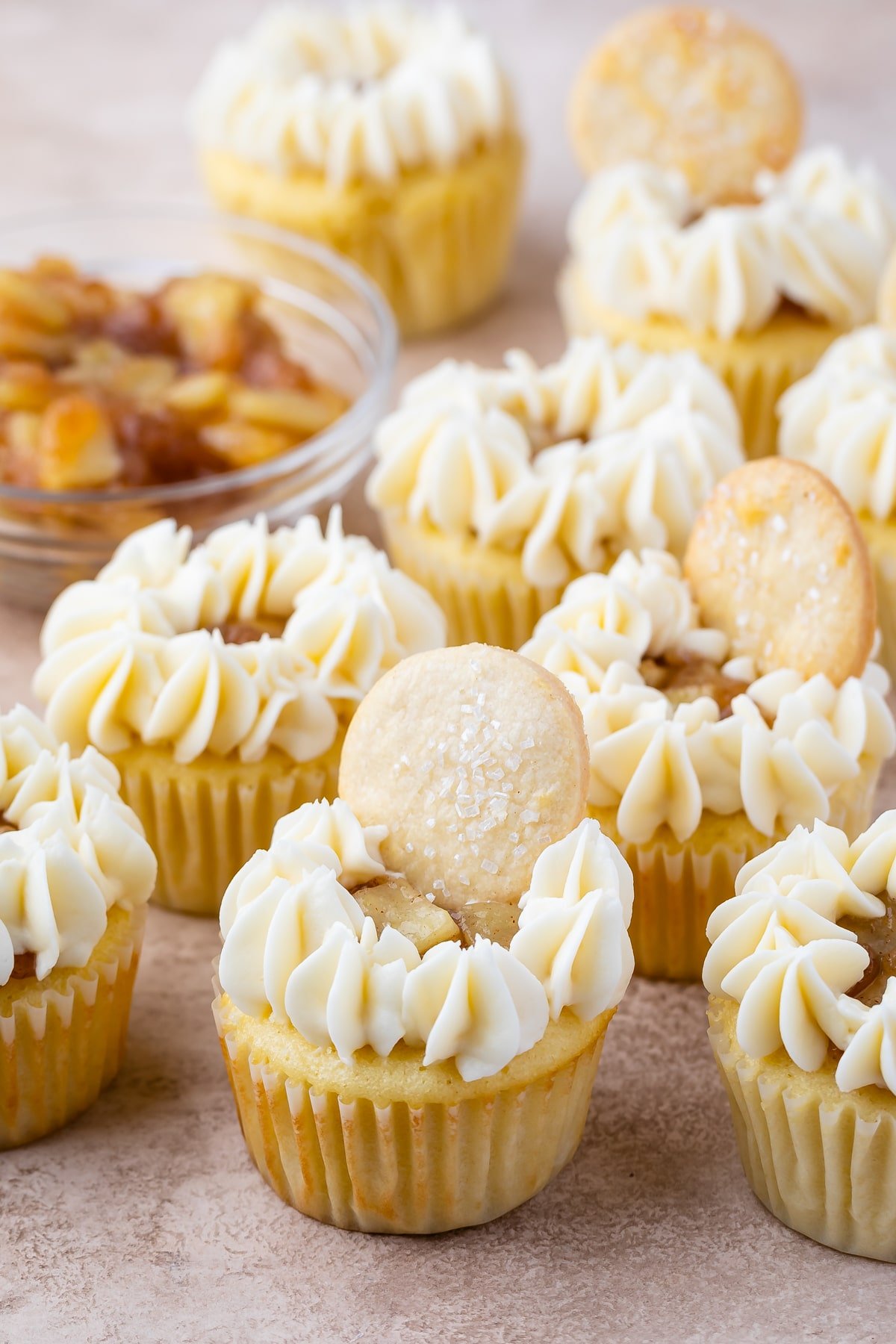 mini cupcakes with frosting and small apple slices on top