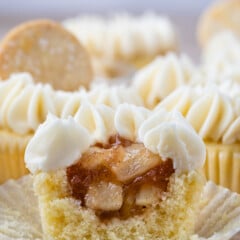 cupcake with white frosting cut in half to show apple filling