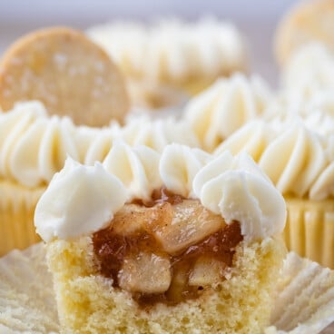 cupcake with white frosting cut in half to show apple filling