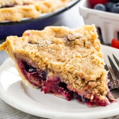 One slice of mixed berry pie on a plate with fork