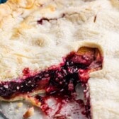 full pie with a slice taken out of it in a clear pie pan with words on the photo