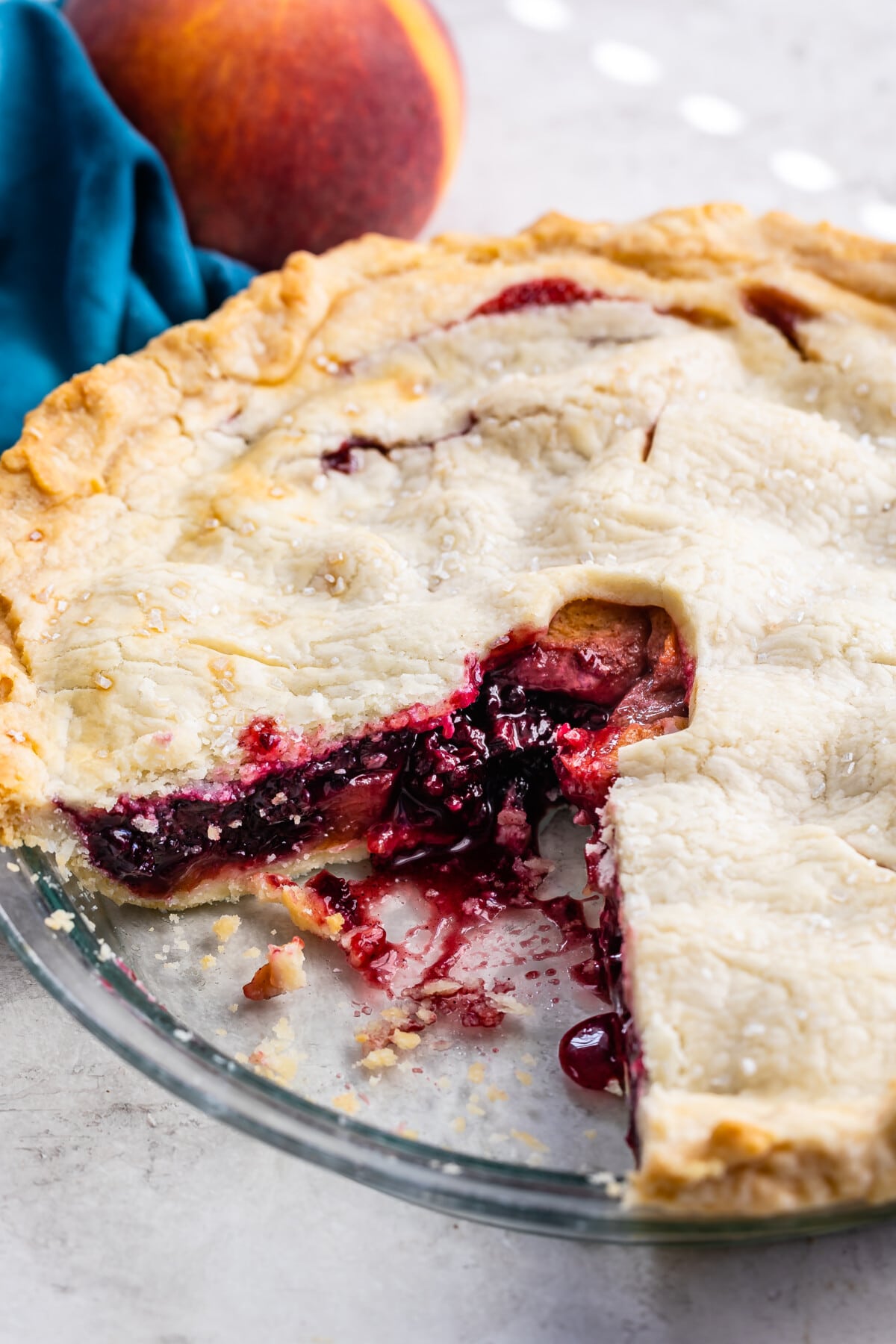 full pie with a slice taken out of it in a clear pie pan