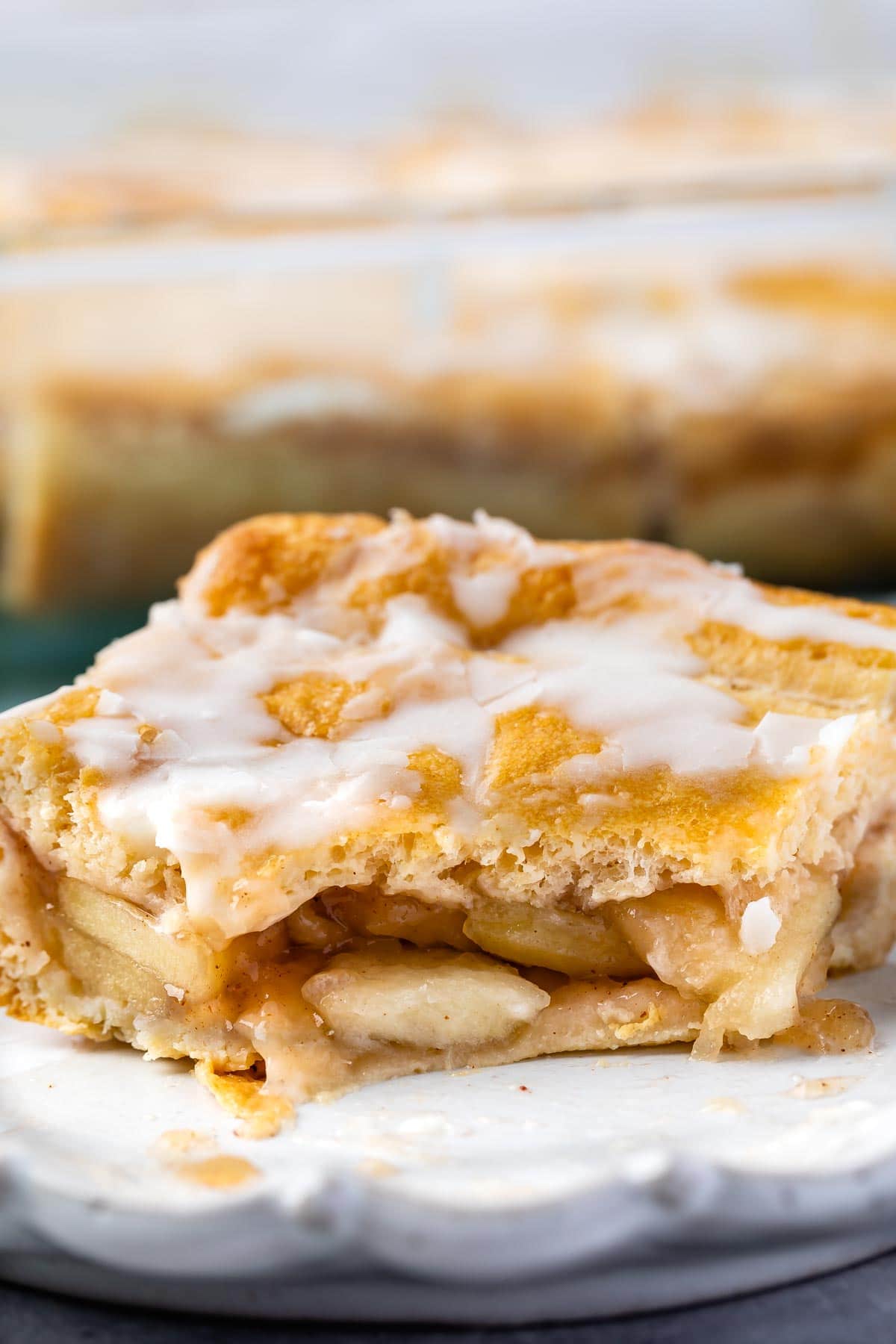 one slice of pie on a light grey plate with frosting on top