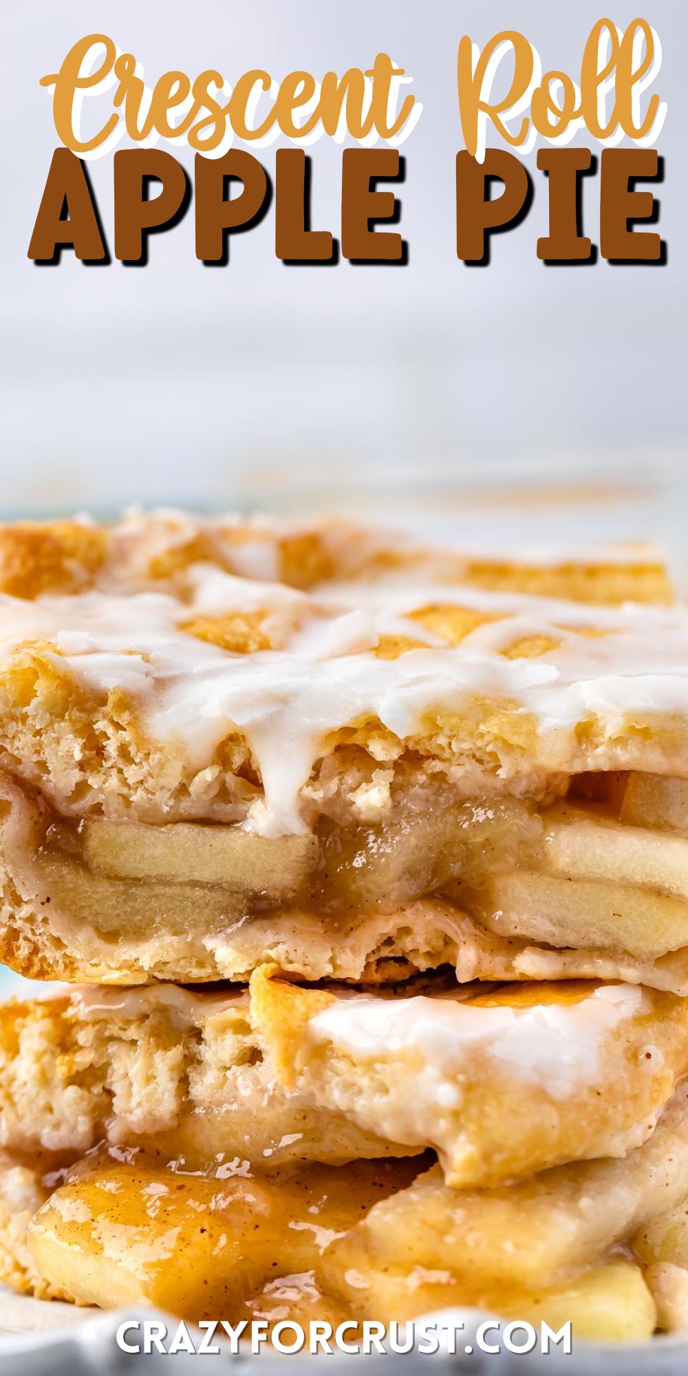 two slices of apple pie with frosting on top sitting on a light grey plate with words on the photo