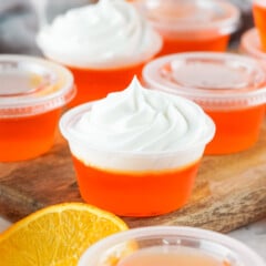 Orange creamsicle jello shots topped with whipped cream