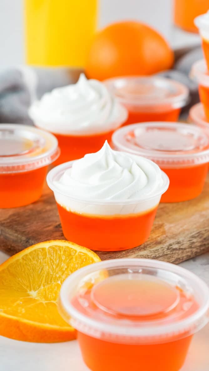 Orange creamsicle jello shots topped with whipped cream