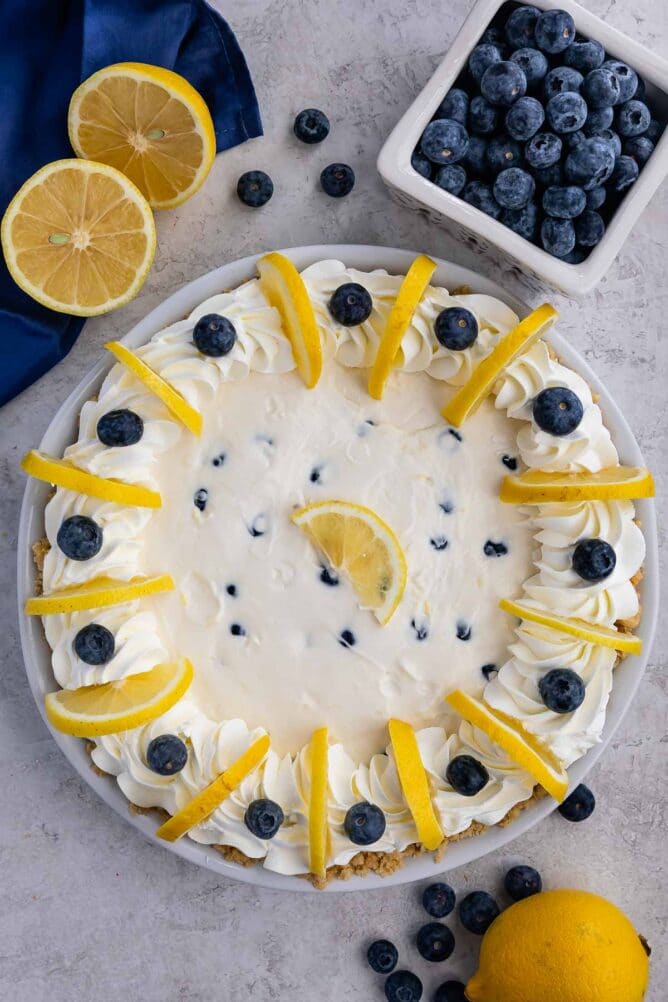 Overhead shot of lemon blueberry pie surrounded by blueberries and lemons