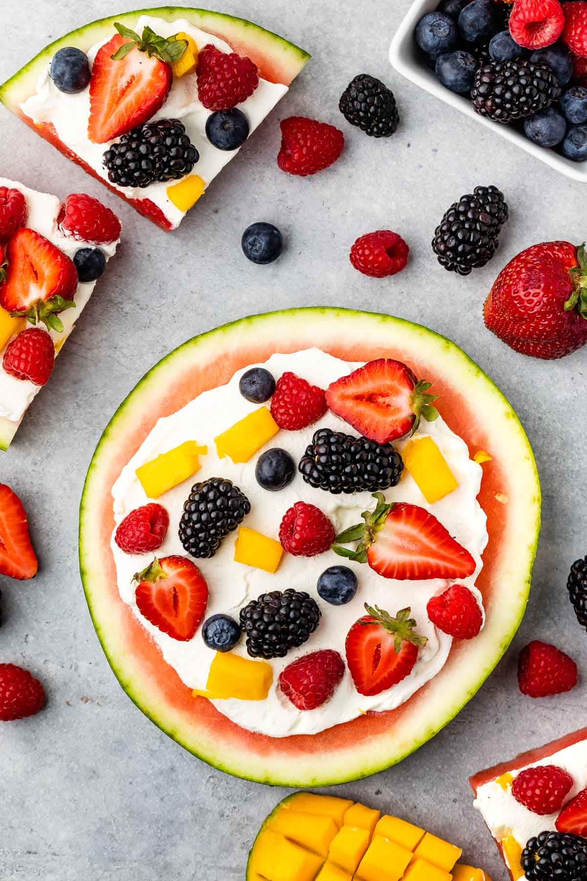 watermelon pizza on grey board with berries around