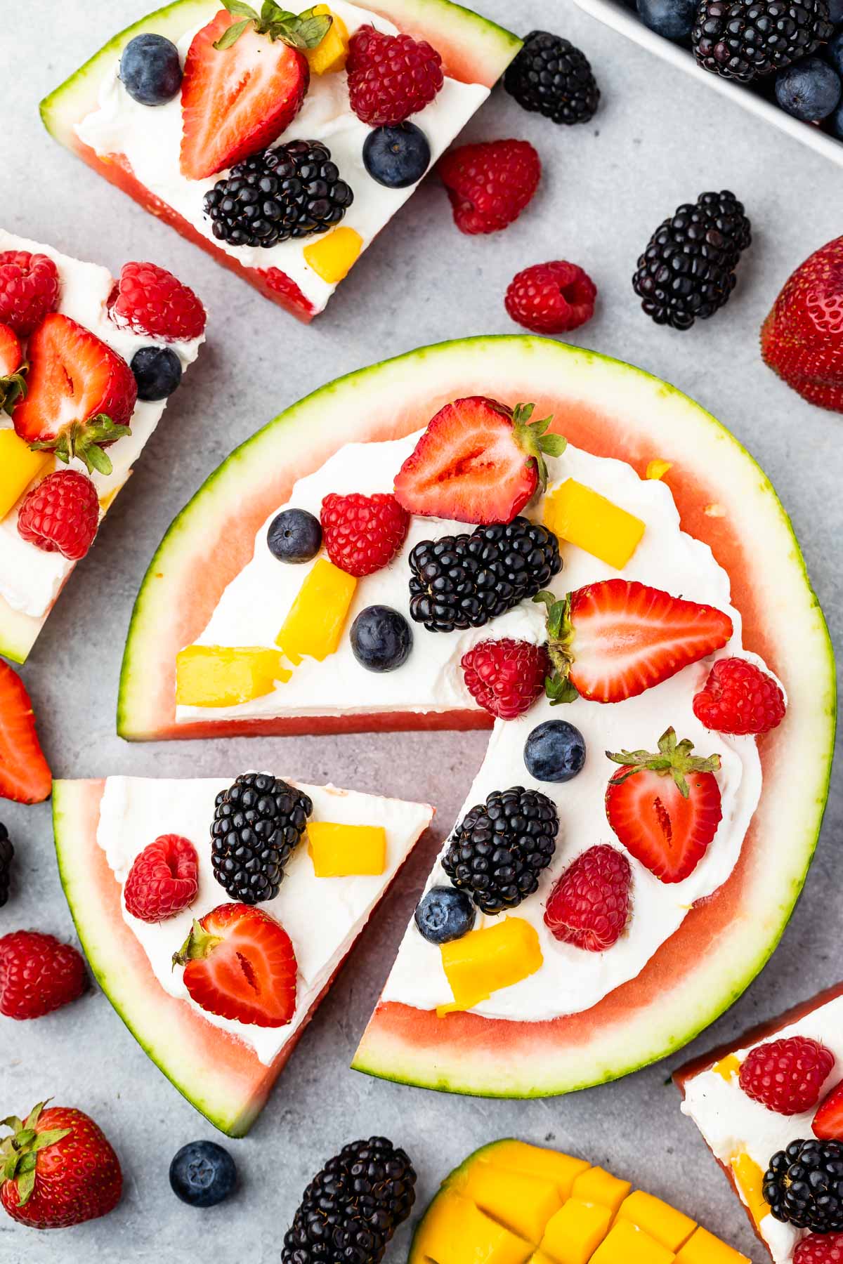 watermelon pizza on grey board with berries around