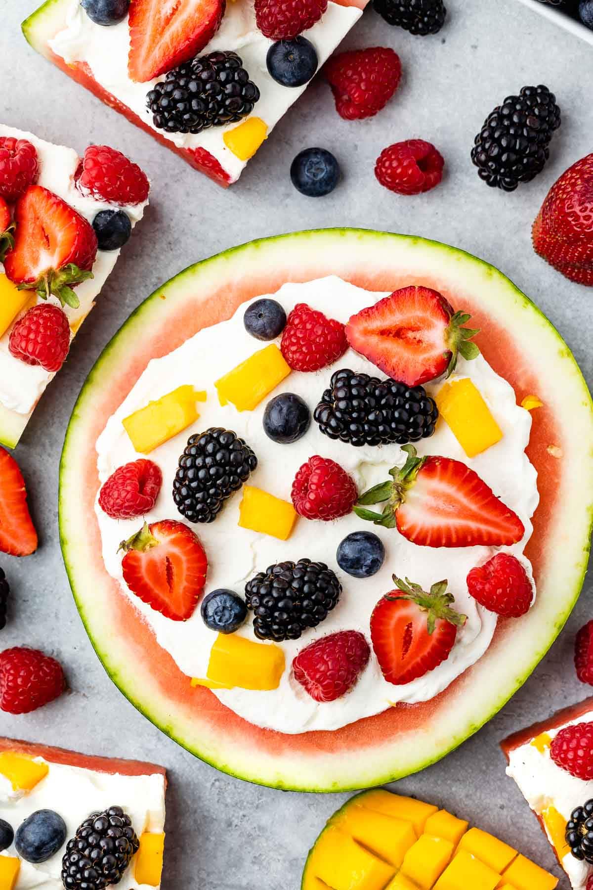 watermelon pizza on grey board with berries around