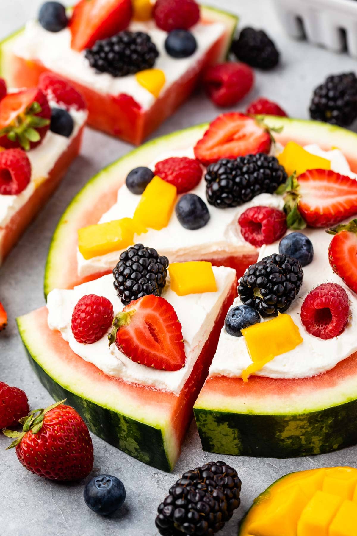 watermelon pizza on grey board with berries around