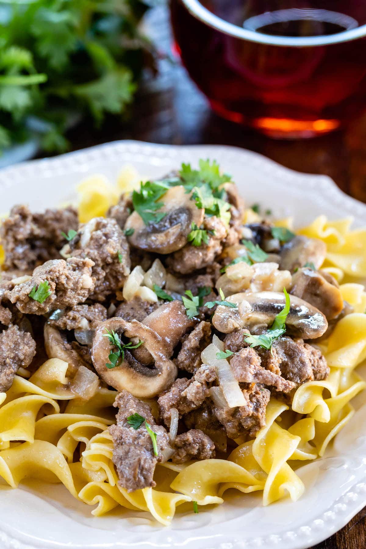 mushrooms and meat on pasta in a white plate