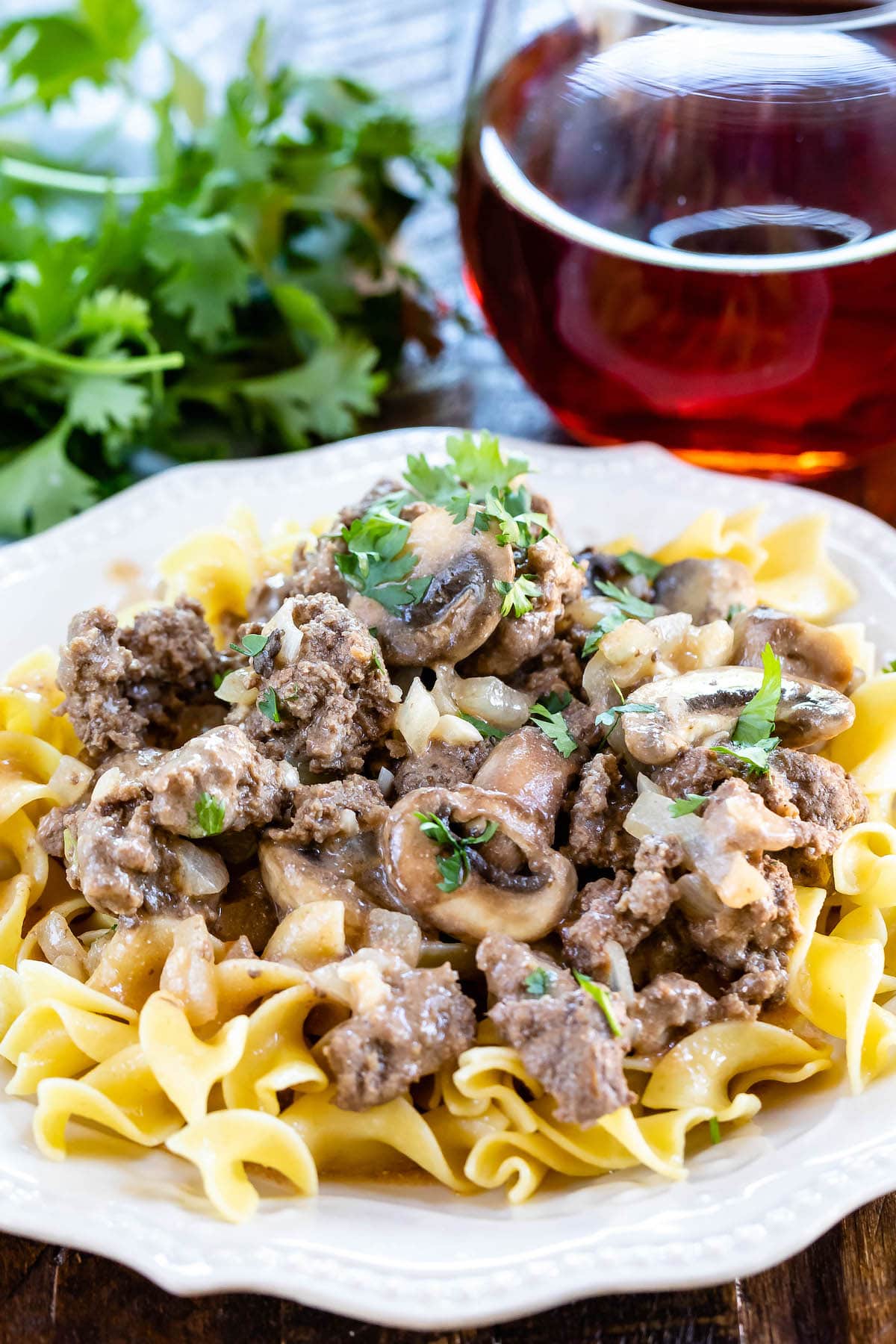 mushrooms and meat on pasta in a white plate