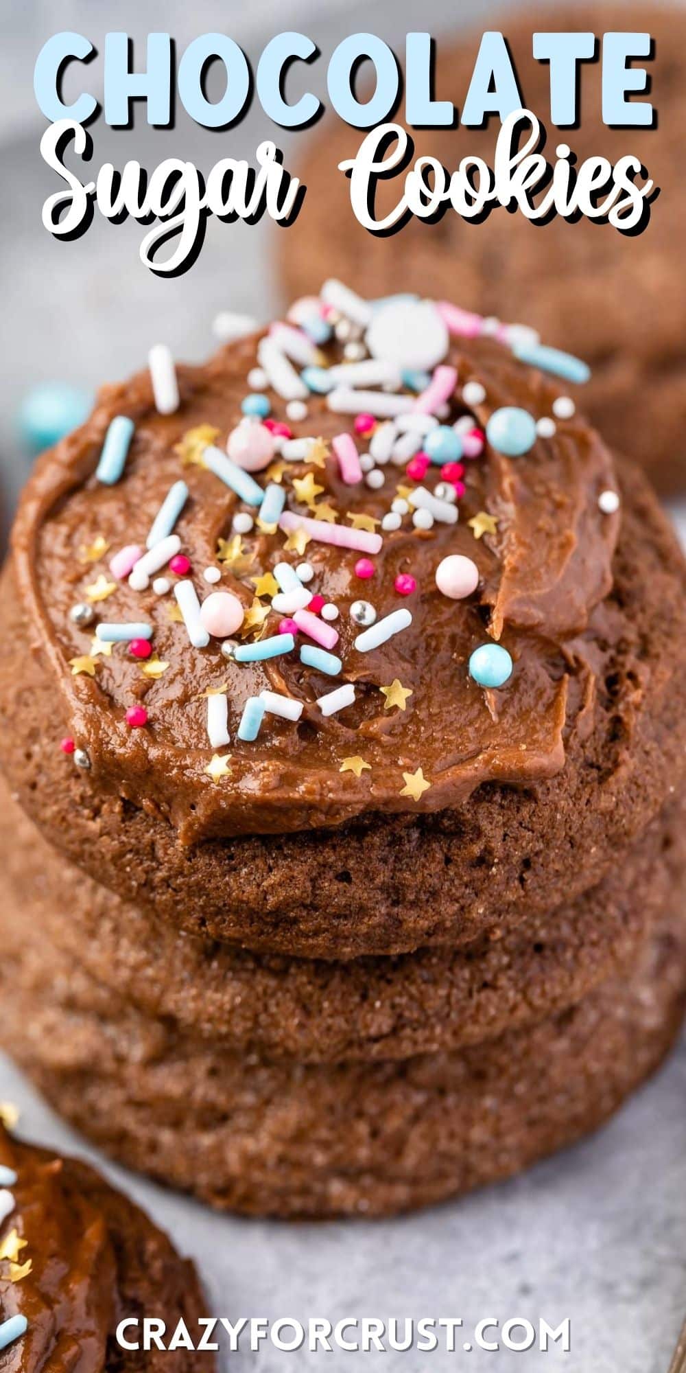 stacked chocolate cookies with the one on top frosted with colorful sprinkles with words on top