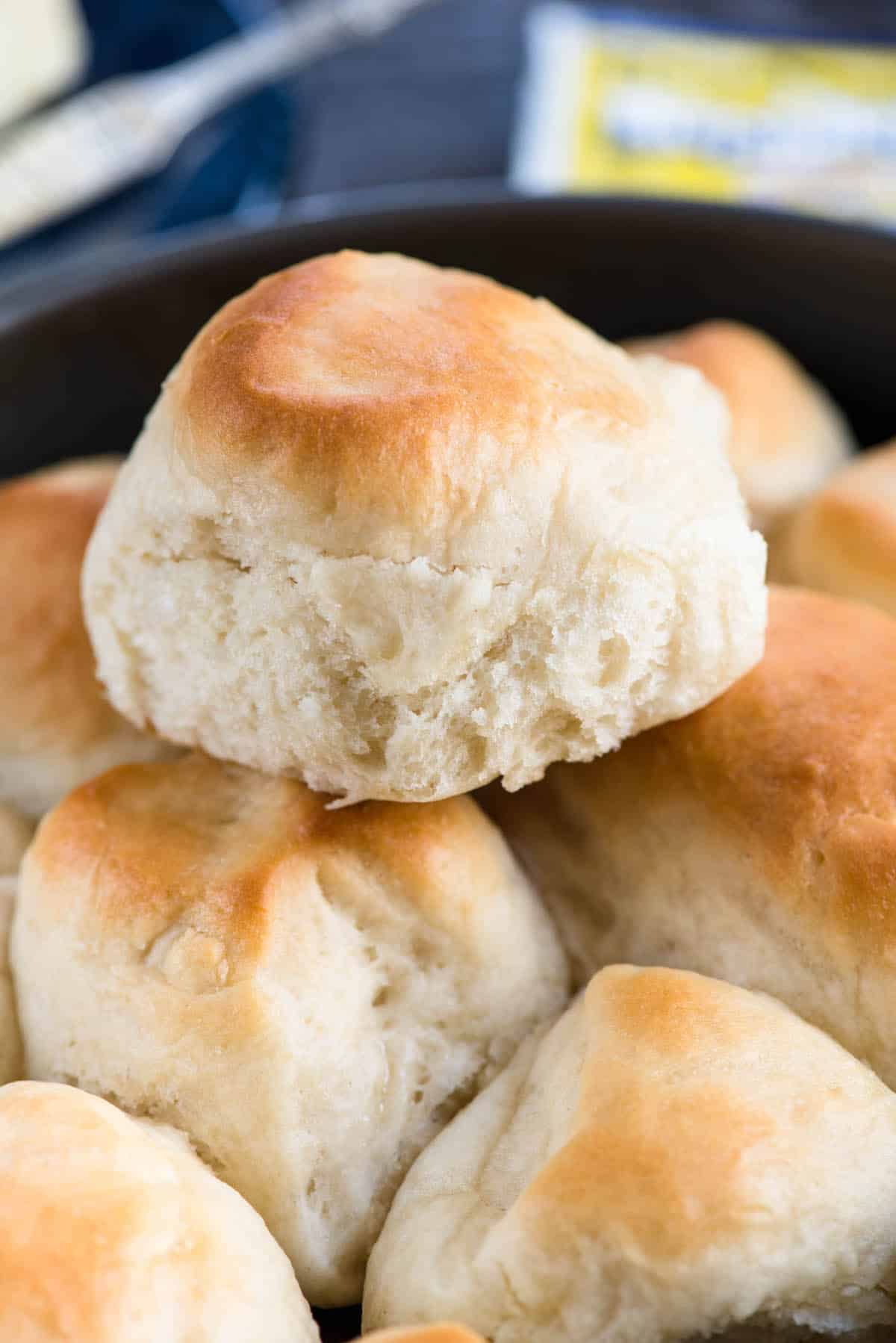 dinner roll stacked on other rolls in a black pan