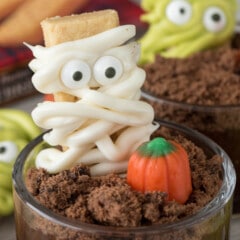 mummy decorated cookie in a dirt cup next to a candy corn pumpkin