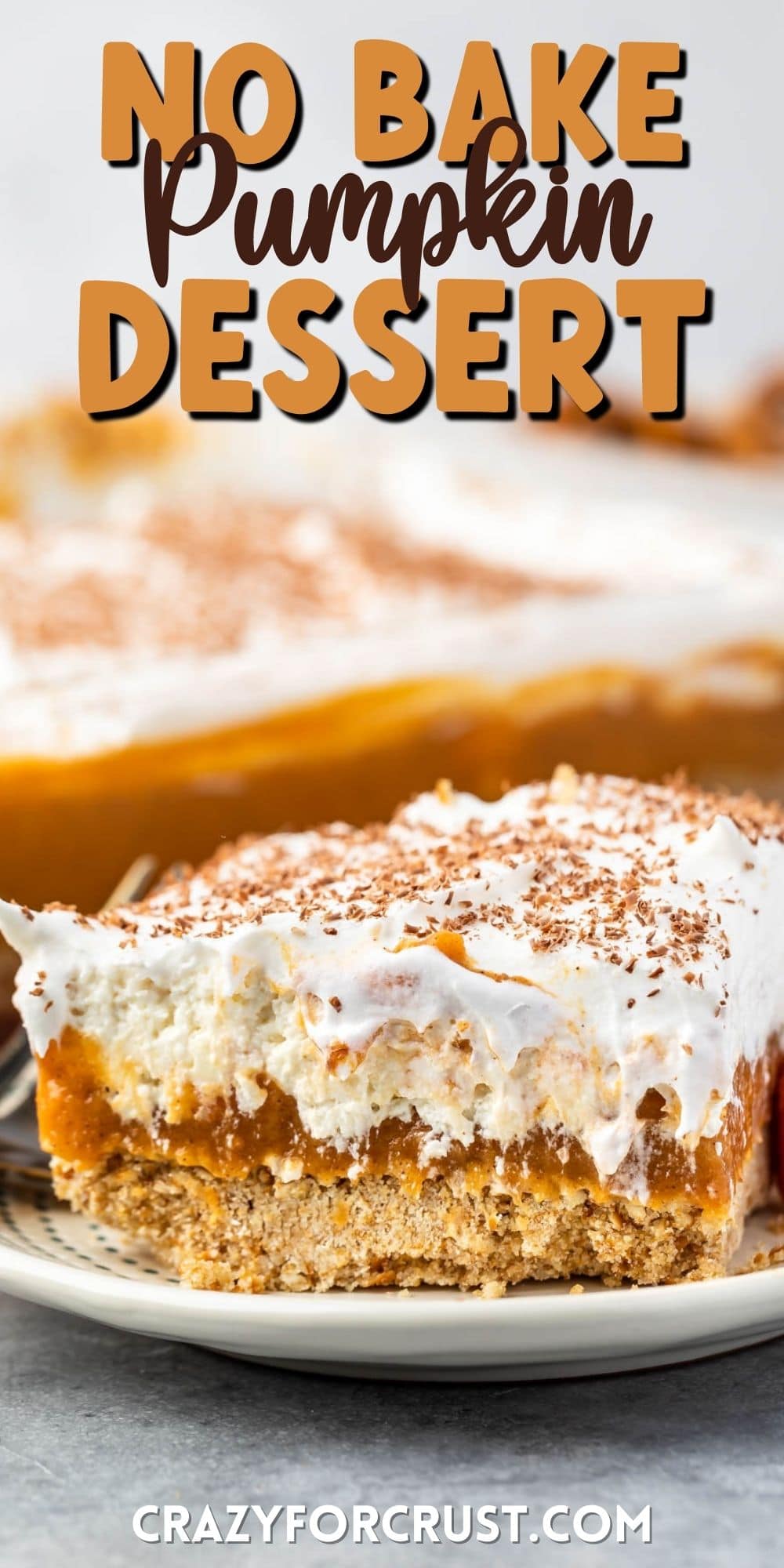 a slice pumpkin dessert sitting on a white plate with white frosting and pumpkin topping and words on the photo