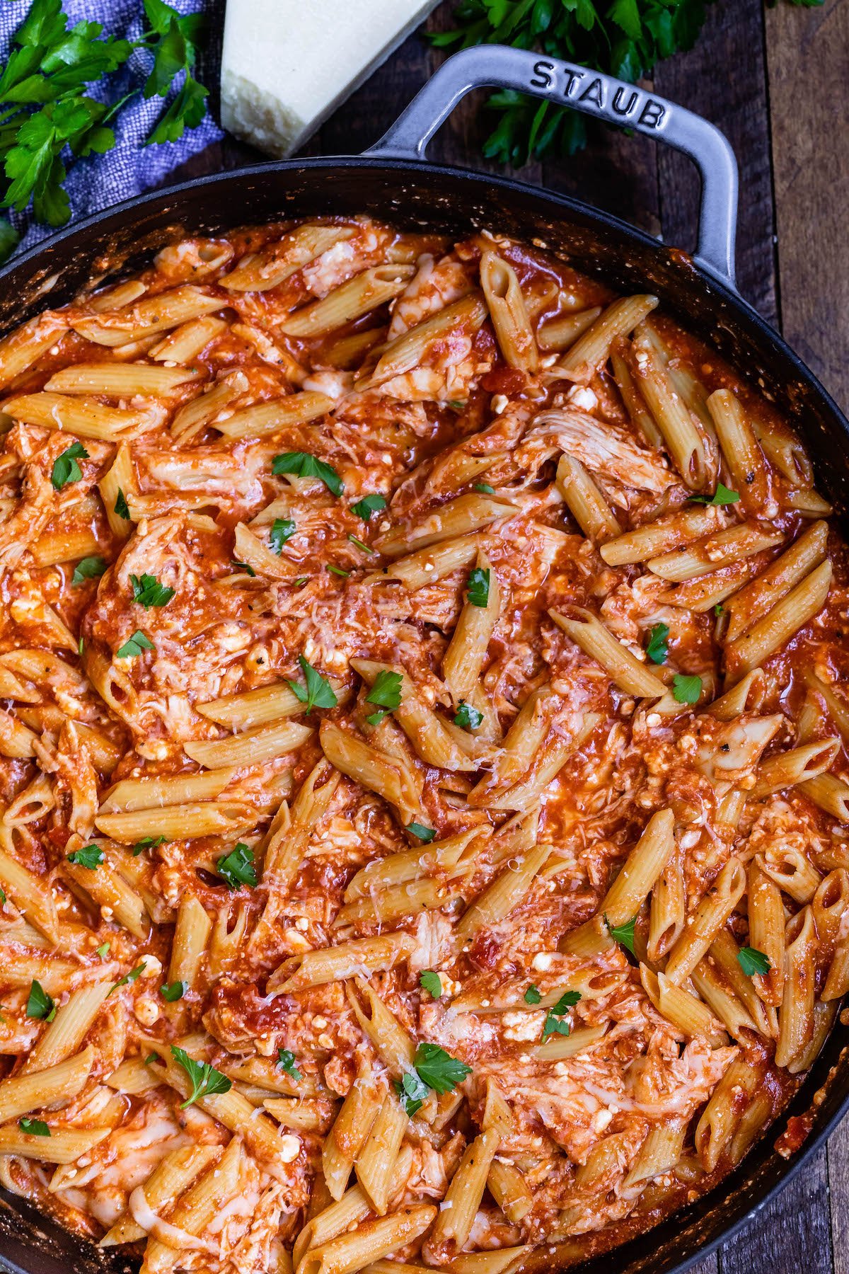 pasta mixed with herbs and sauce in a black pan