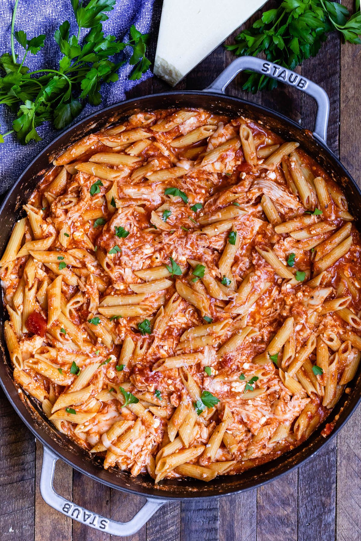 pasta mixed with herbs and sauce in a black pan