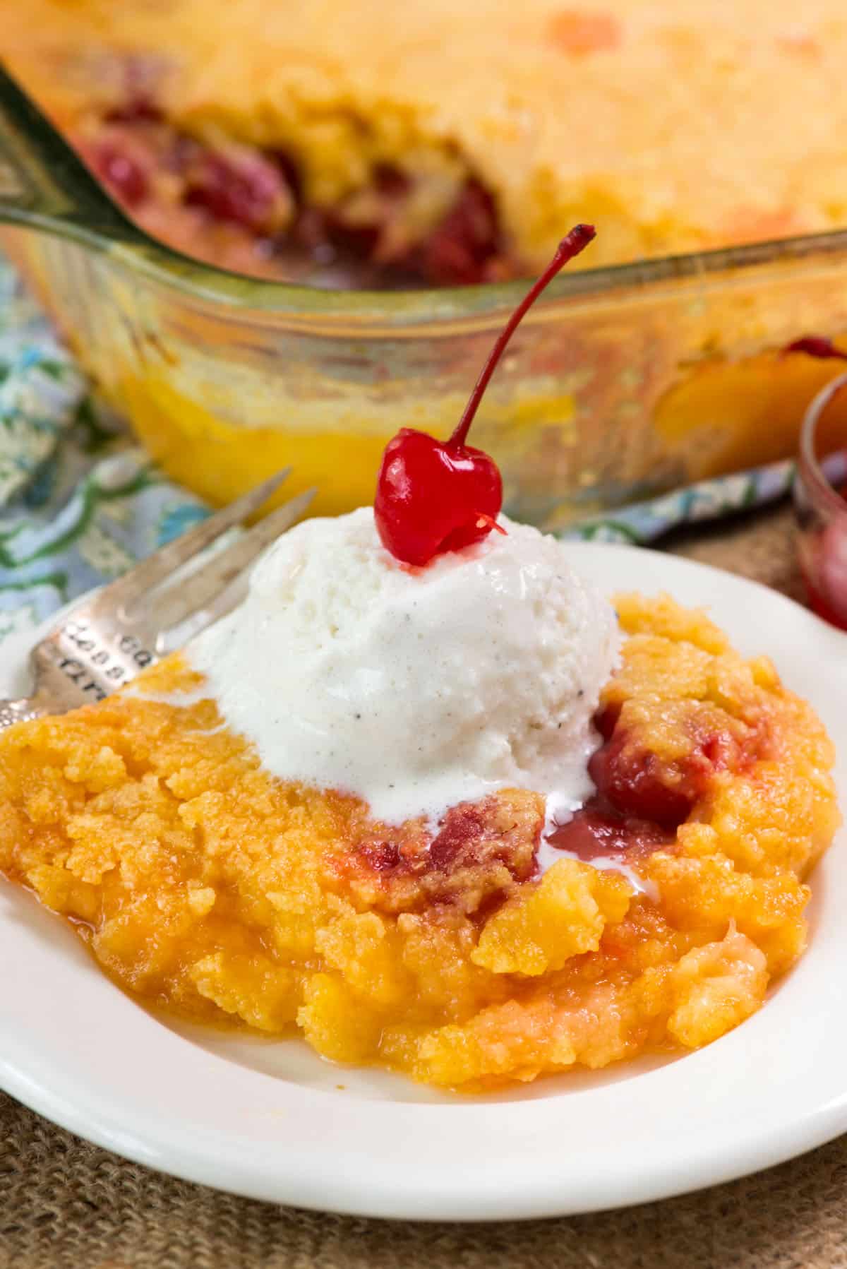 pineapple cake on white plate with ice cream and cherry