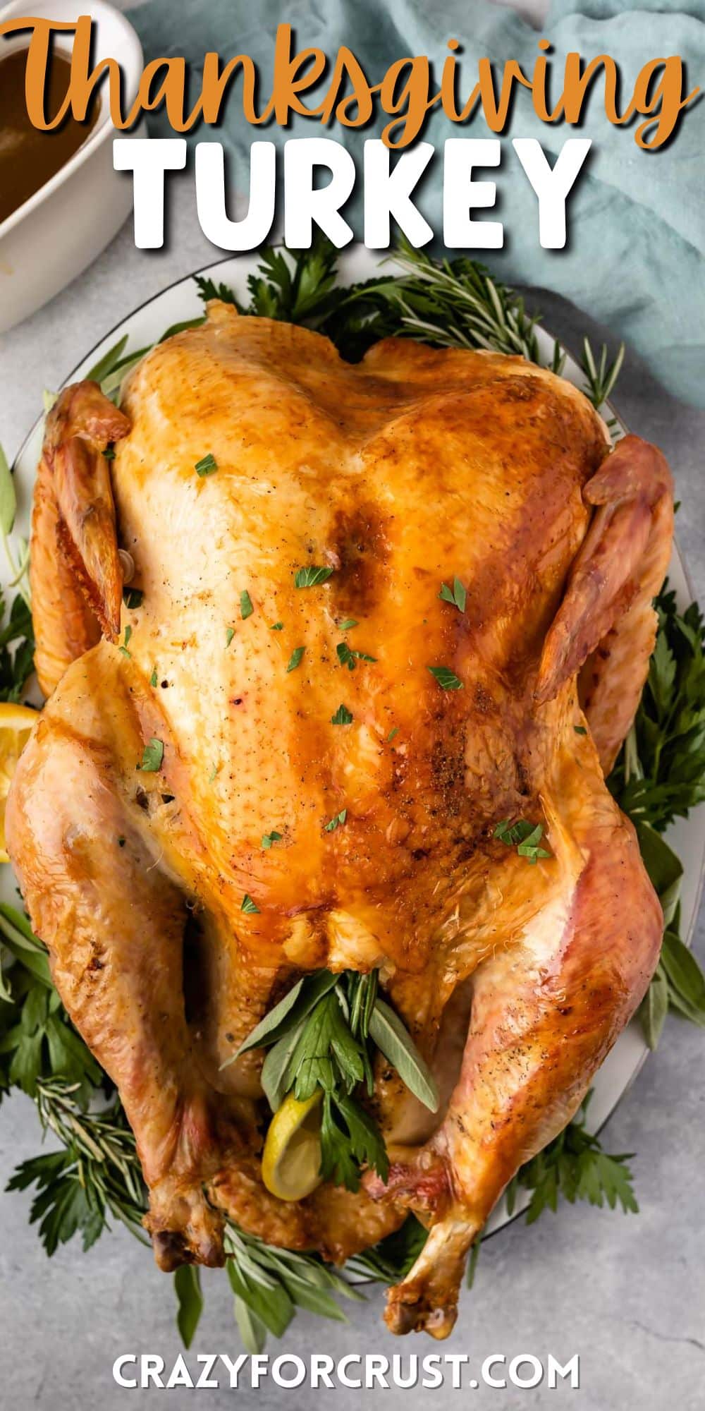 stuffed baked turkey surrounded by herbs on a white plate with words on top