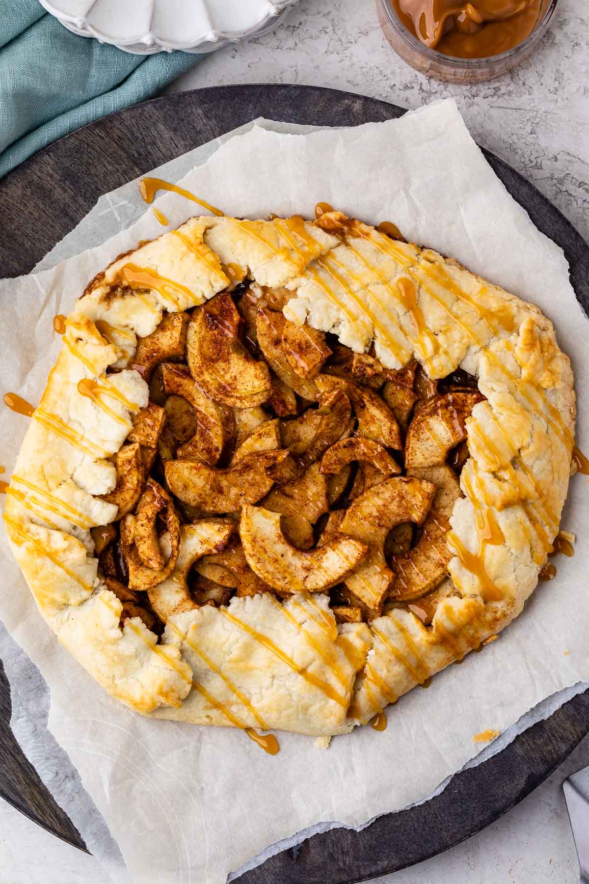 apple dessert cooked on parchment paper with caramel drizzled on top
