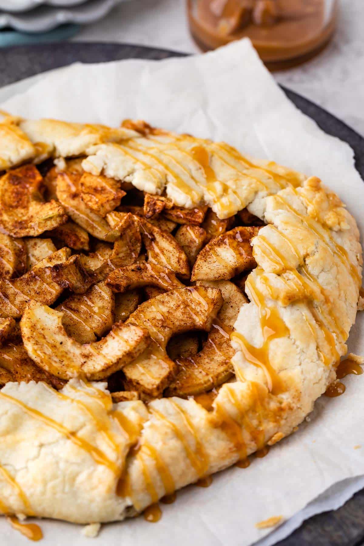 apple dessert cooked on parchment paper with caramel drizzled on top