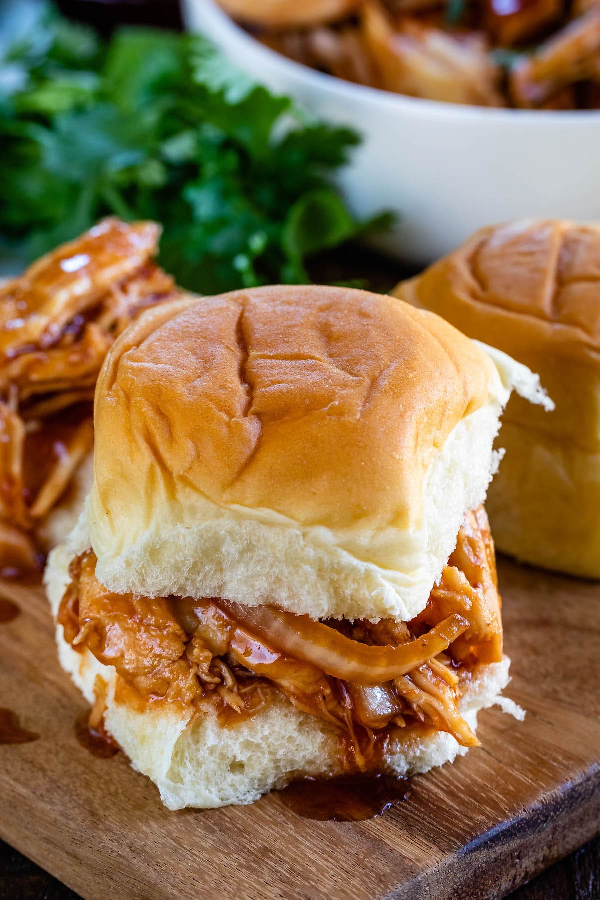 chicken and onions between a roll of bread on a cutting board