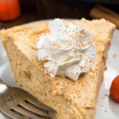 pumpkin pie on a grey plate with a fork next to it and words on the top go the photo